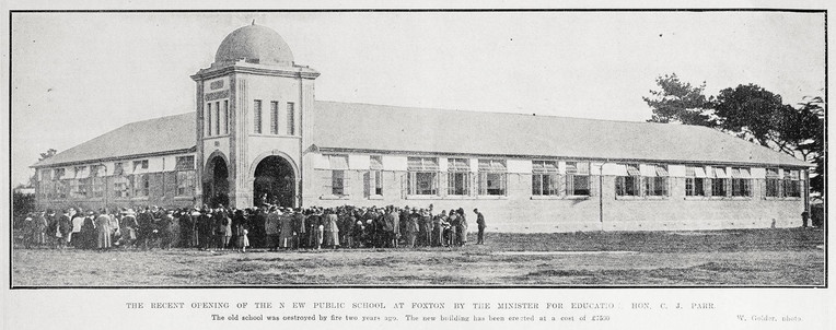 Black-and-white photo: The official opening of the new public school at Foxton. Photographer, W. Golder. Description: A small crowd gathers for the official opening of the new public school at Foxton by the Minister for Education, the Honourable C. J. Parr. The new building cost £7500 [ca. $860,000 today] and replaced the old school which was destroyed by fire two years previously. Citation: Auckland Weekly News, 1 July 1920, p. 38. Auckland Libraries Heritage Collections AWNS-19200701-38-01. https://kura.aucklandlibraries.govt.nz/digital/collection/photos/id/227955