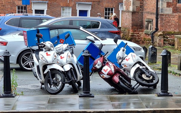 Small scooters with Dominos livery that have fallen over against each other