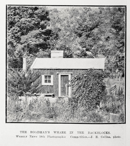 Black-and-white photo: The roadman’s whare in the backblocks. 1921. Photographer, J. E. Collins. Description: A view of a wooden-walled hut with a single door and a short chimney. One window is visible. There is bush in the background, including trees. Citation: Auckland Weekly News, 28 July 1921, p. 36. Auckland Libraries Heritage Collections AWNS-19210728-36-03. https://kura.aucklandlibraries.govt.nz/digital/collection/photos/id/241561