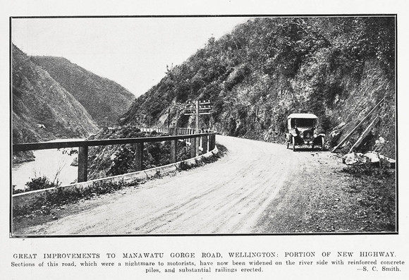 Black-and-white photo: Great Improvements To Manawatu Gorge Road Wellington: Portion of New Highway. 1924. Photographer, S. C. Smith. Extended caption: Sections of this road, which were a nightmare to motorists, have now been widened on the river side with reinforced concrete piles, and substantial railings erected. Description: Shows a car facing the camera parked at the side of the metalled road, with the hillside abutting the road to the viewers right, the gorge river visible below at left and the hillsides of the other side of the gorge to the far left. Citation: Supplement to the Auckland Weekly News, 25 September 1924, p. 44. Auckland Libraries Heritage Collections AWNS-19240925-44-03. https://kura.aucklandlibraries.govt.nz/digital/collection/photos/id/245768