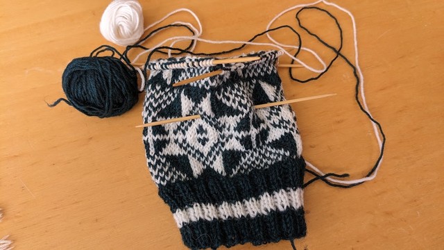 深緑と白の毛糸を使った編み物の画像