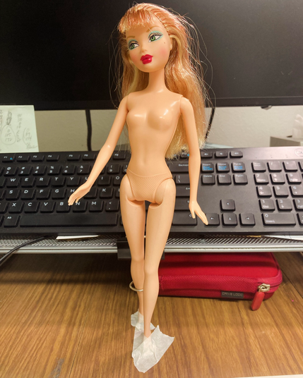 Fashion doll posed on a desktop. 