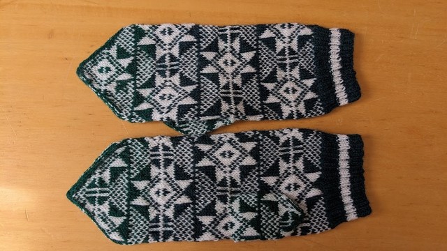 Image of mittens knitted in two colors of dark green and white