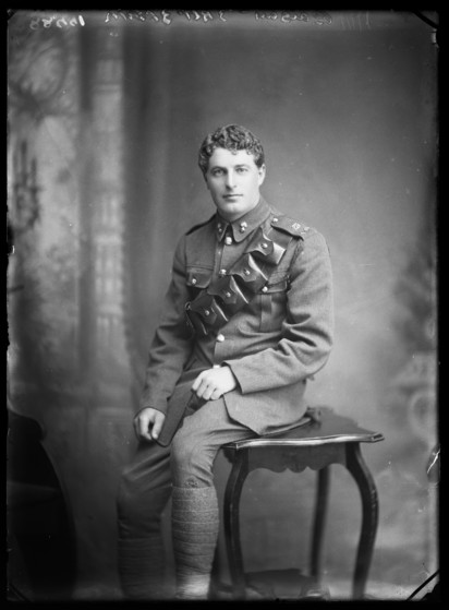 Black-and-white portrait photo: Ashley Heath Baigent. 1917. Photography, Berry & Co., Wellington. Description: The soldier in this almost-full portrait is wearing military uniform, but without a hat. He has short hair, is clean-shaven and seated on a small table. has been identified as Gunner Ashley Heath Baigent of the New Zealand Field Artillery.  Ashley was a farmer from Takaka at the time he attested for service on 8 January 1917. He was assigned to the 25th Reinforcements, New Zealand Field Artillery  but was found to have a goitre and therefore ‘unfit for active service’. Citation: Museum of New Zealand Te Papa Tongarewa (B.044366). https://collections.tepapa.govt.nz/object/362531