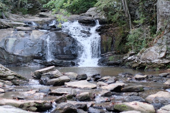 A waterfall in a park, water cascading over rocks